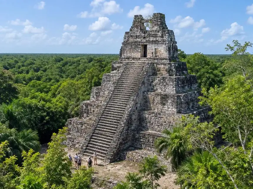 El Castillo, the tall stepped temple at the Muyil ruins, rising above the jungle